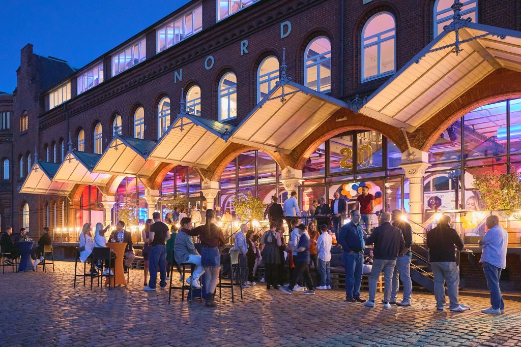 Auf dem Bild zu sehen, Abenddämmerung auf der 20 jährigen Jubiläumsfeier von webgo. Draußen mit Blick auf die Eventlocation "Nord Event" in der Hamburger Speicherstadt.