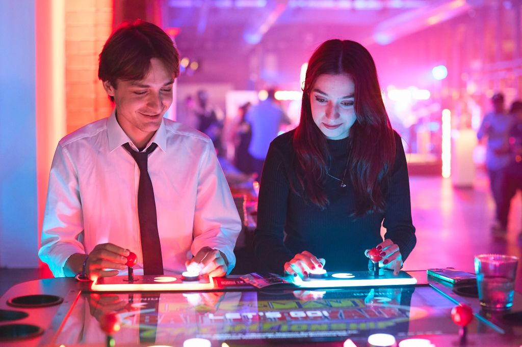 Auf dem Bild zu sehen: Abseits der Tanzfläche nutzen viele auch die Arcarde Game Station und zocken Pac-Man Battle Royale Championship!.
