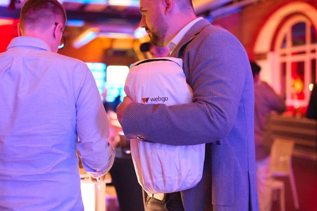 Auf dem Bild zu sehen: Ein Gast unserer Jubiläumsfeier mit dem wasserdichten webgo Rucksack inklusive Picknickdecke im Arm.