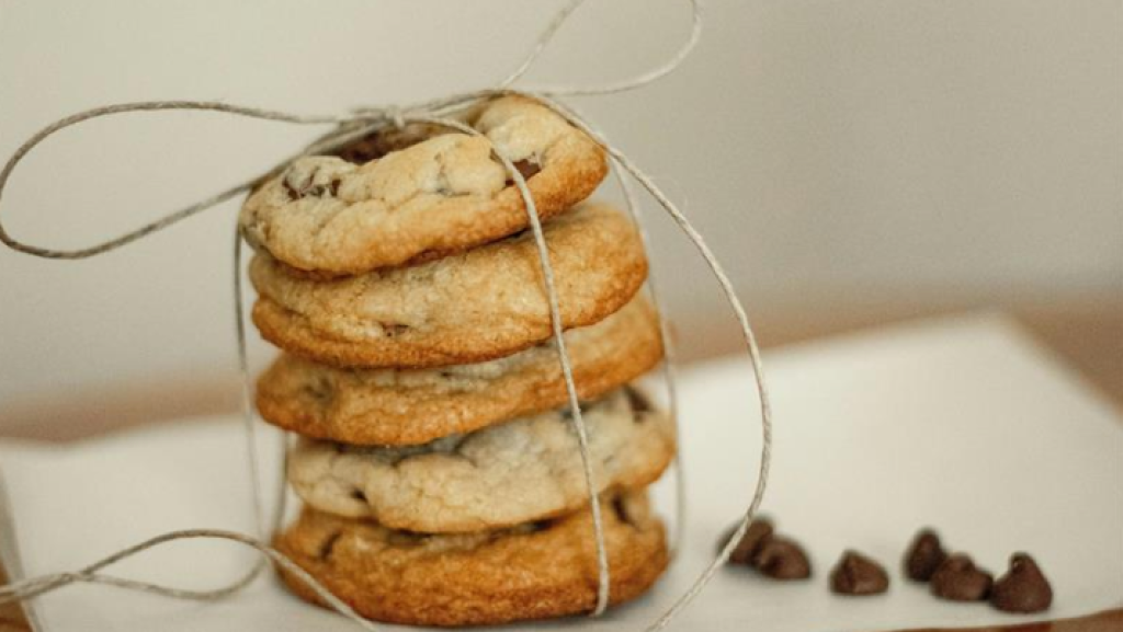 Vier Schoko-Cookies als Stapel mit einer Schnur verschnürt, dekorativ arrangiert auf hellem Untergrund. Symbolbild für Cookies auf Websites – im Kontext von Cookie-Hinweisen und DSGVO-konformer Einwilligung.