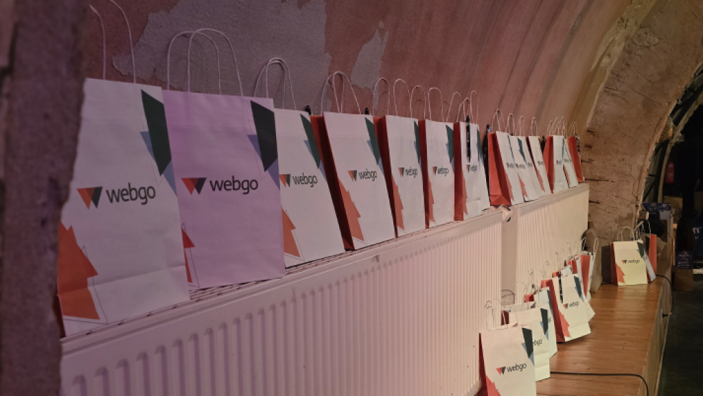 Mehrere webgo-Goodiebags mit modernem Design stehen aufgereiht auf einem Heizkörper bei der WordCamp Leipzig 2025 Veranstaltung.