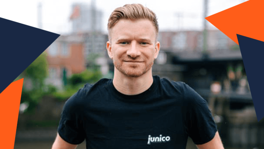 Matthias Beckh, Mitgründer von Junico.de, steht am Wasser in Hamburg, trägt ein schwarzes T-Shirt mit 'junico' Schriftzug, umgeben von orange-blauen Dreieck-Elementen der webgo GmbH.