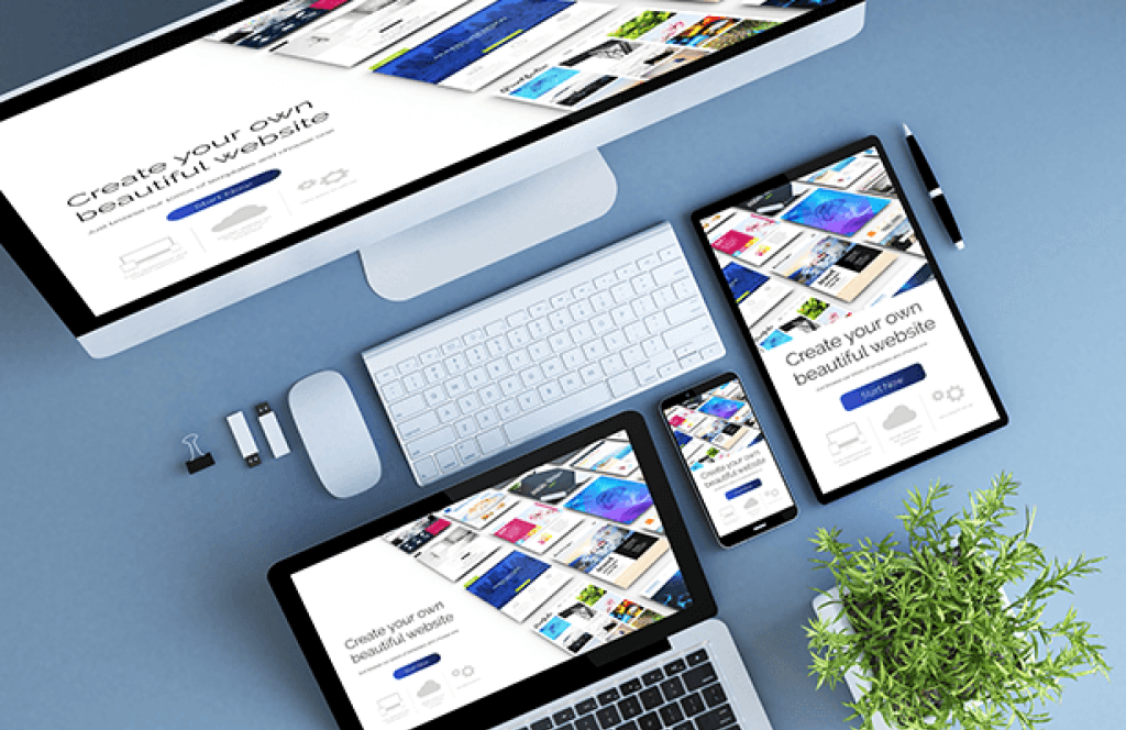 Desktop-Computer, Tablet und Smartphone mit Webdesign-Oberfl&auml;che zur Erstellung moderner, responsiver Websites auf blauem Schreibtisch mit Zubeh&ouml;r.
